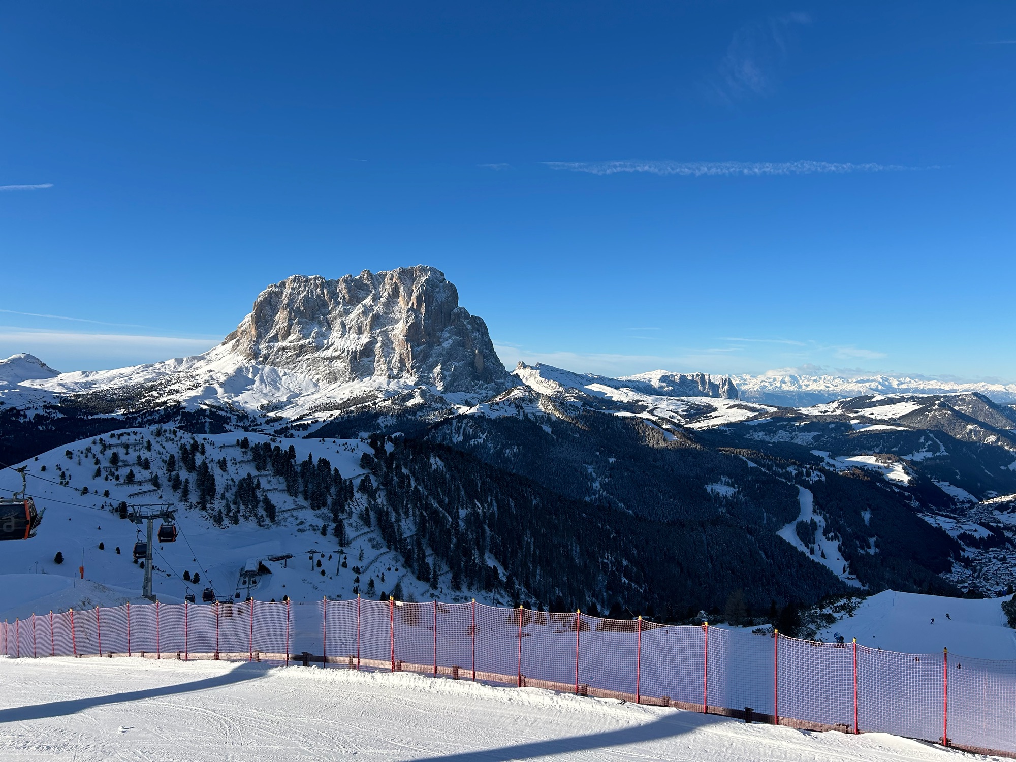 Il Sassolungo innevato sopra le piste della Val Gardena, con una cabinovia